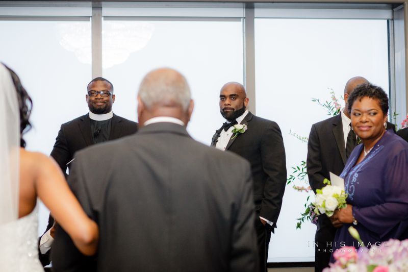 Groom watches bride come down the isle