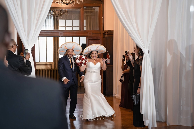 couple entering their wedding reception in sombreros