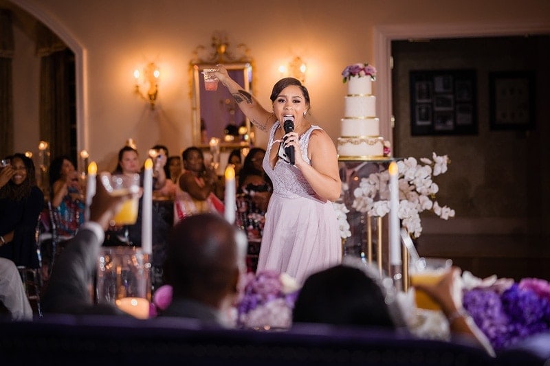 A bridesmaid delivering a heartfelt speech to the bride during her wedding reception.