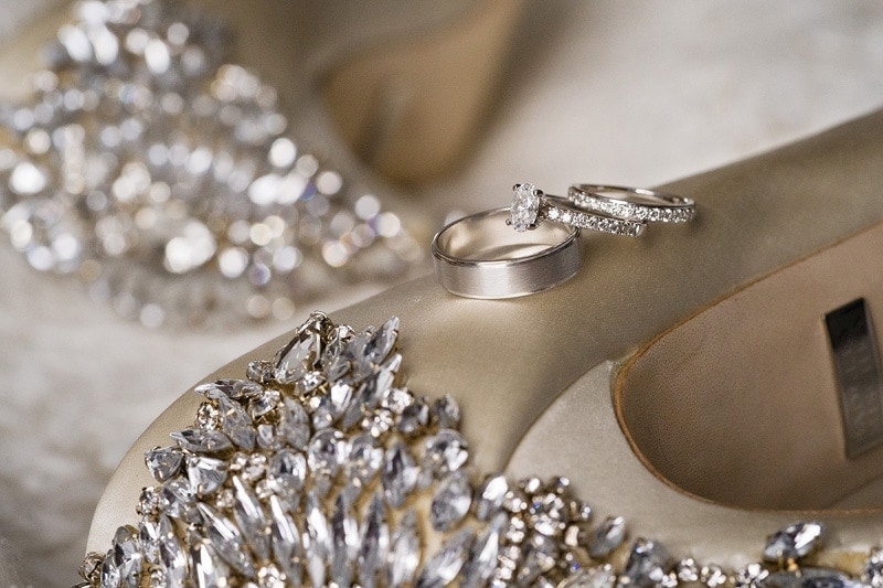 Wedding shoes with a wedding ring on them.