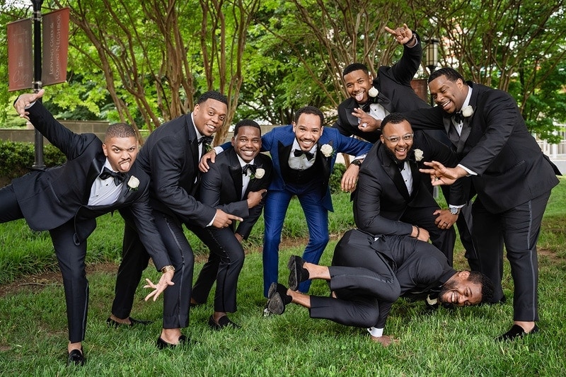 Wedding groomsmen in tuxedos posing for a photo.