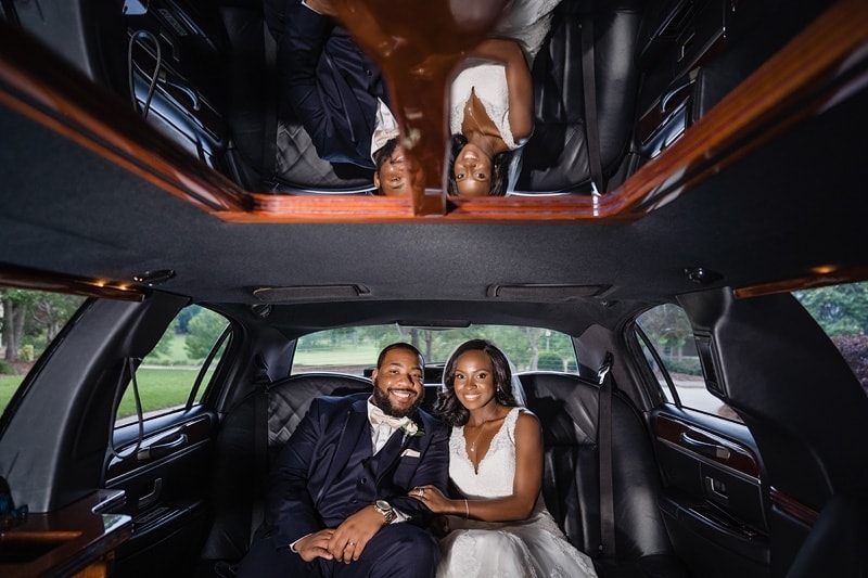 A bride and groom sitting in the back of a limo, captured by talented wedding photographers.
