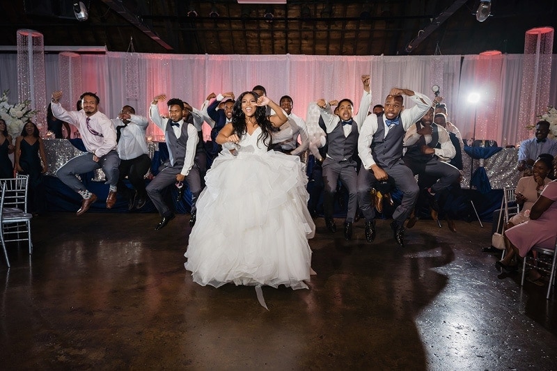 A joyful bride, groom and groomsmen captured in a candid moment at their wedding reception.