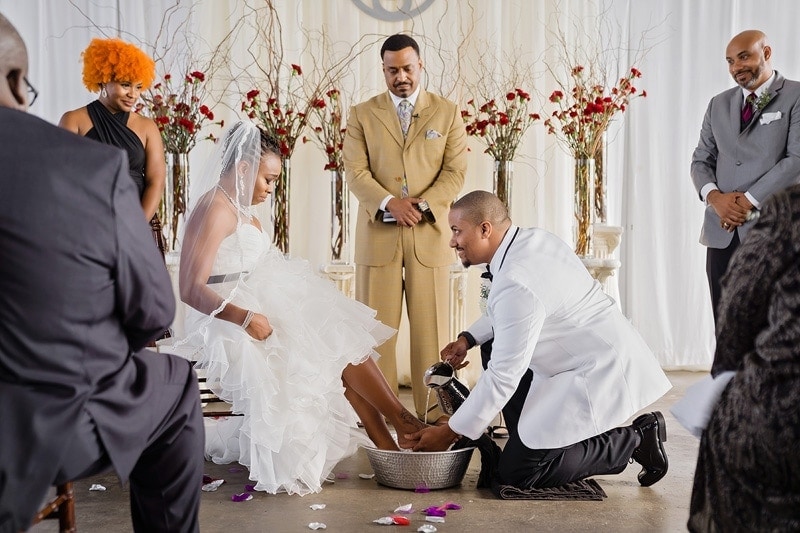 Groom washing his brides feet during their wedding ceremony.