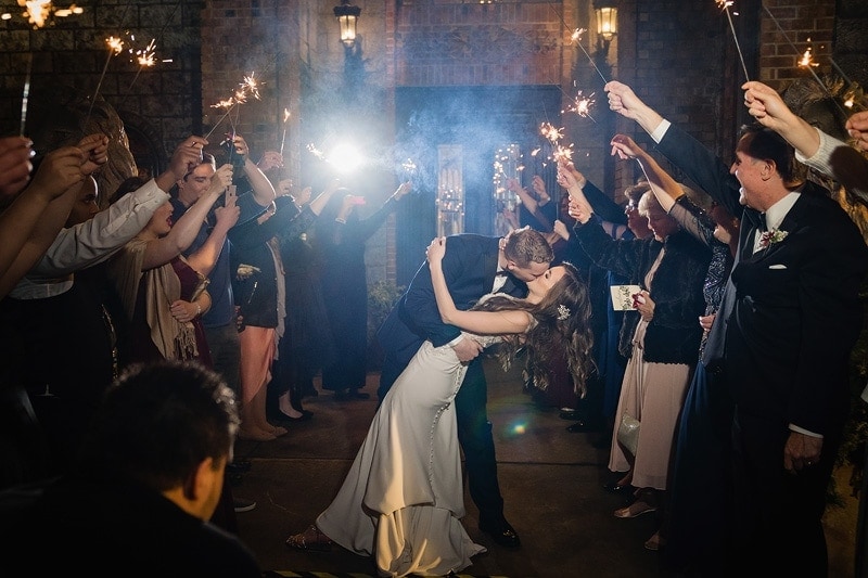 Wedding photography: A stunning image capturing the beautiful moment of a bride and groom sharing a passionate kiss amidst the enchanting glow of sparklers on their wedding day.
