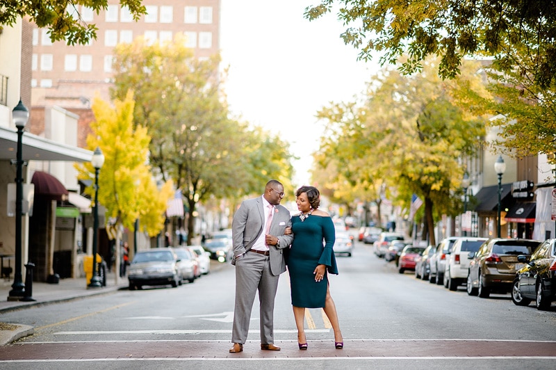 An engaged couple standing on a city street, captured by an engagement photographer.