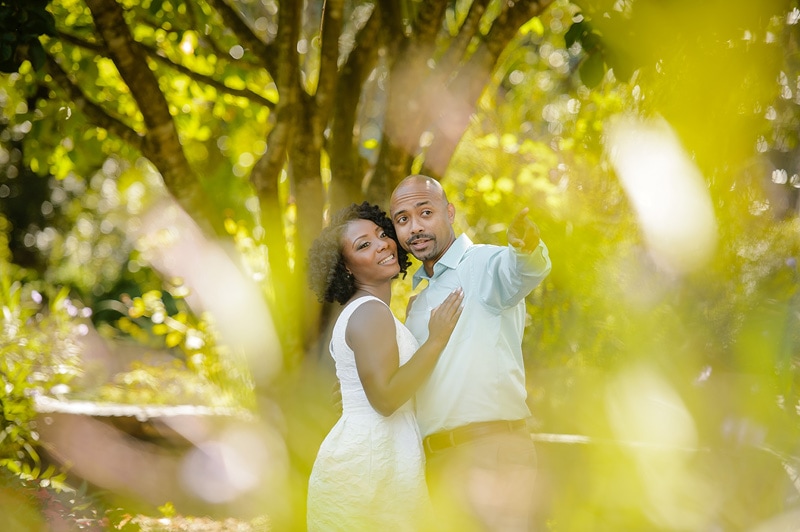 An engagement photographer captures a couple's love while they pose for their engagement photos in a beautiful park.