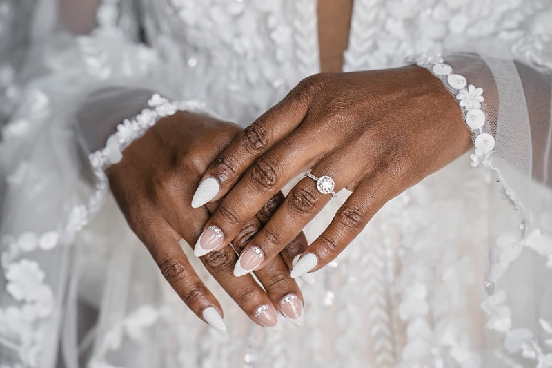 At the exquisite distillery wedding, captured in this image, one can admire the graceful hands of a glowing bride adorned with a sparkling wedding ring.