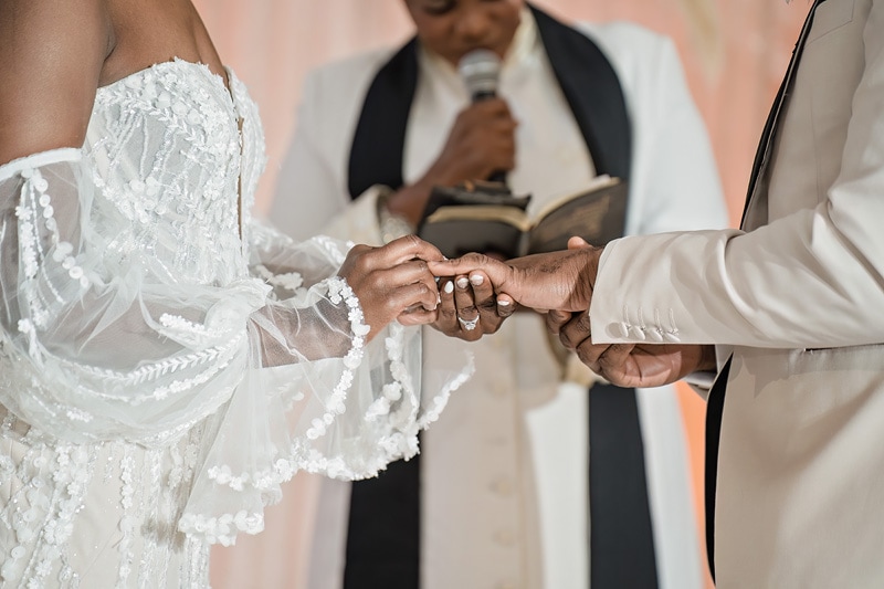 The bride and groom exchange rings during their wedding ceremony at The Distillery wedding venue.