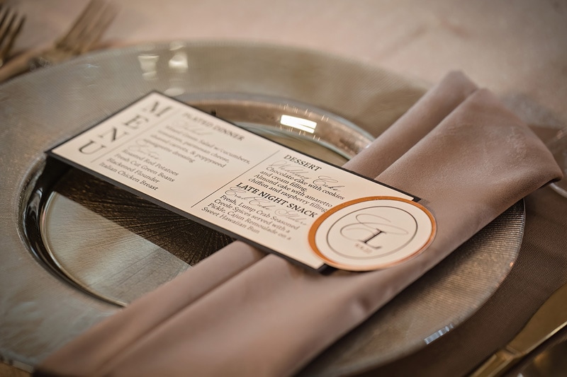 A silver plate with a place card on it, perfect for a stylish table setting at the distillery wedding.