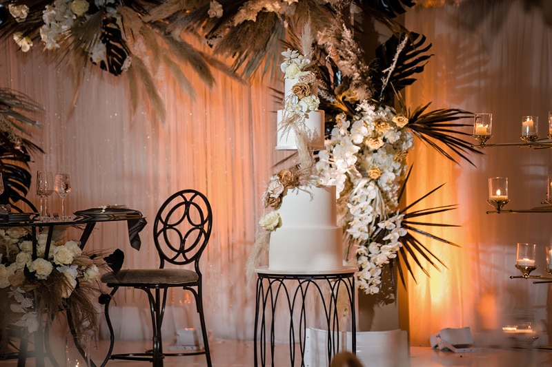 The Distillery wedding reception features a stunning cake and exquisite flowers.