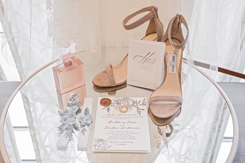 A pair of shoes and a wedding invitation are displayed on the Board & Batten Events Wedding table.