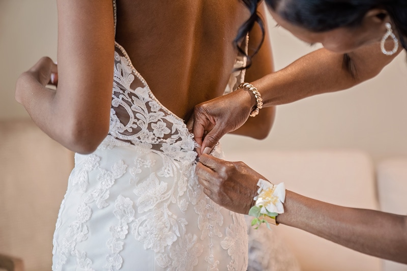 A woman getting ready in a bride's wedding dress at Board & Batten Events Wedding.