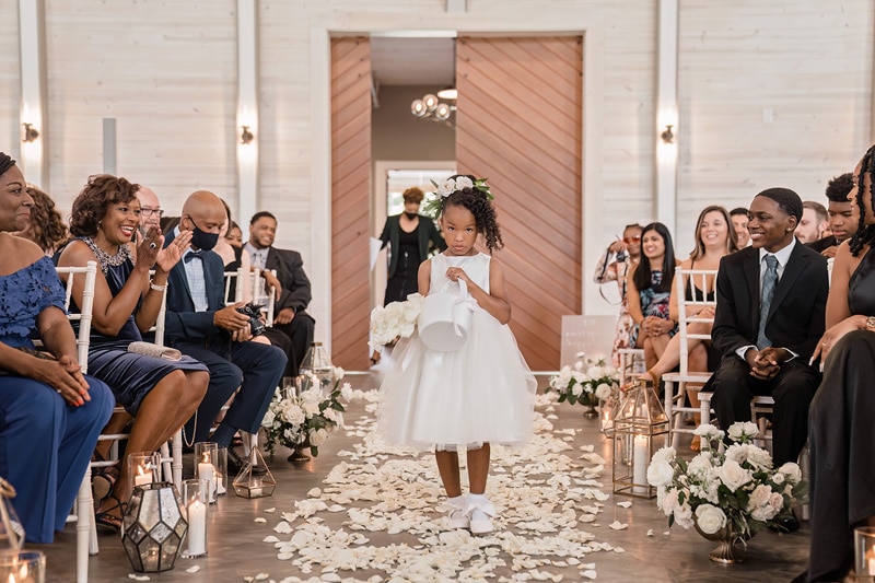 A little girl gracefully walking down the aisle at a Board & Batten Events wedding.