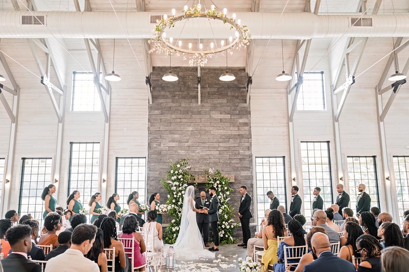 A Board and Batten Wedding ceremony in a large room with a chandelier.