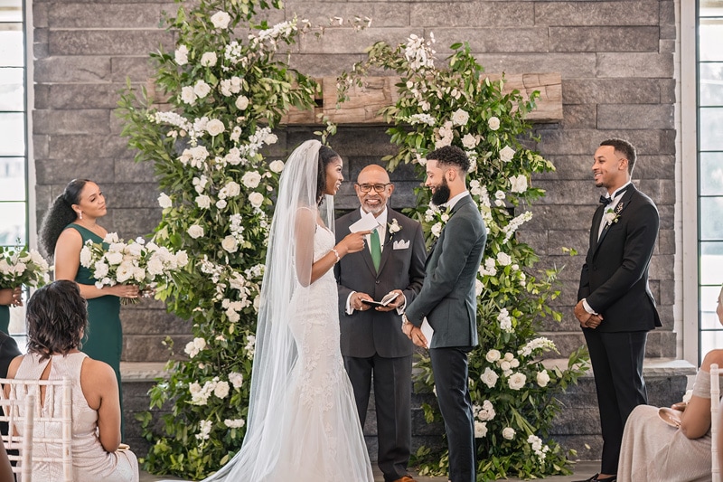 A bride and groom exchange vows at their Board and Batten wedding ceremony.