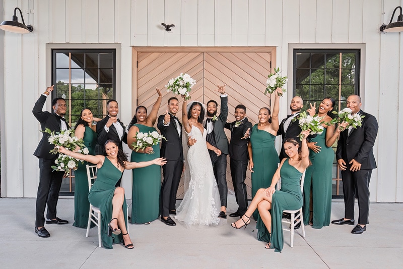 A group of people posing for a Board & Batten Wedding photo.