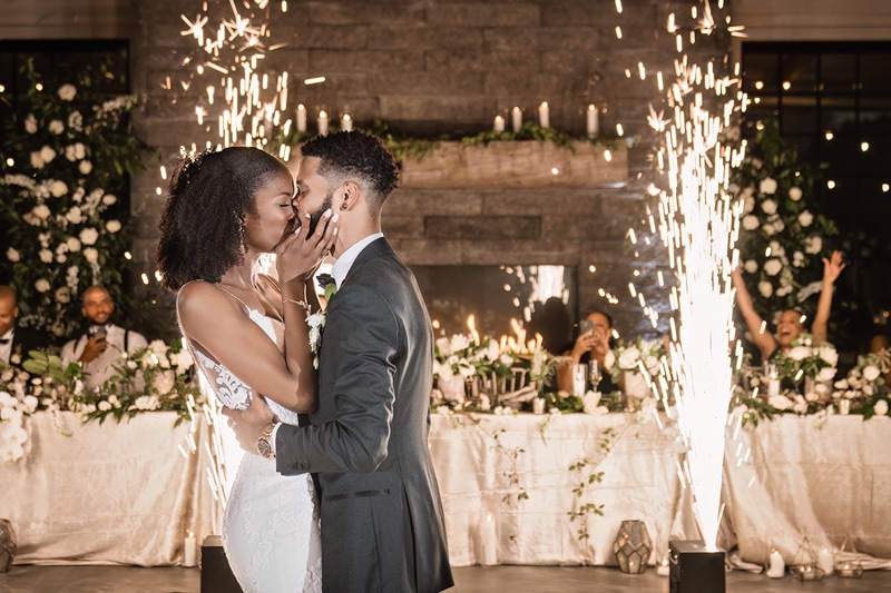 A bride and groom kissing in front of sparklers at a Board & Batten Events Wedding.