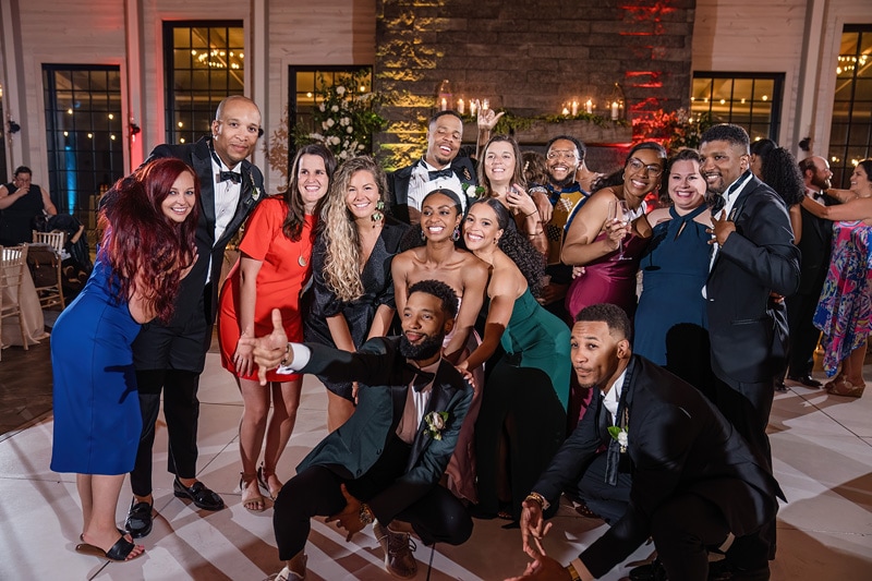 A group of people posing for a photo at a Board & Batten Events wedding reception.