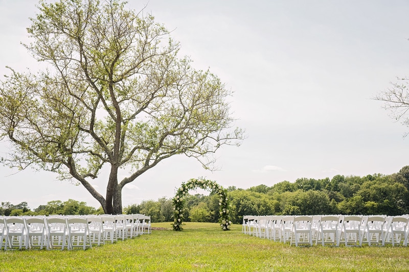 Looking for the perfect outdoor wedding venue in Lexington, NC? Consider a beautiful ceremony surrounded by white chairs and a majestic tree at Board & Batten Events.