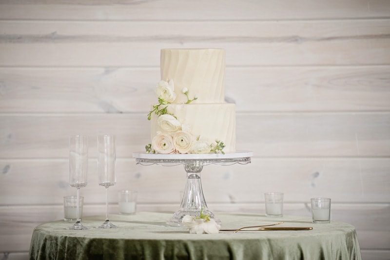 A white wedding cake on a Board & Batten Events green tablecloth in Lexington, NC.