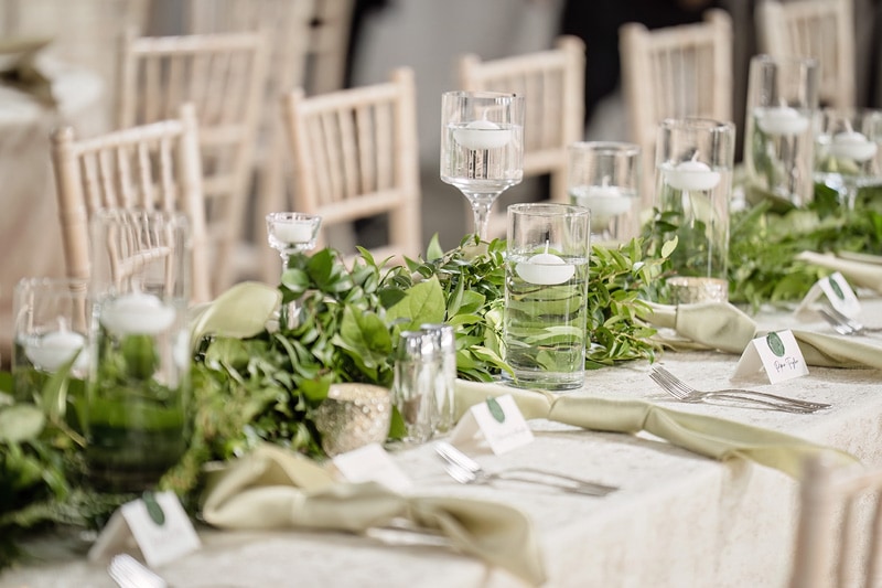 A table set with greenery and candles at Board & Batten Events in Lexington.