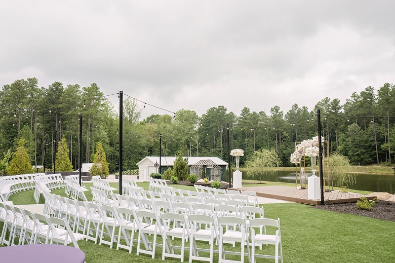 An outdoor Pinehill Pavilion wedding ceremony set up with white chairs.