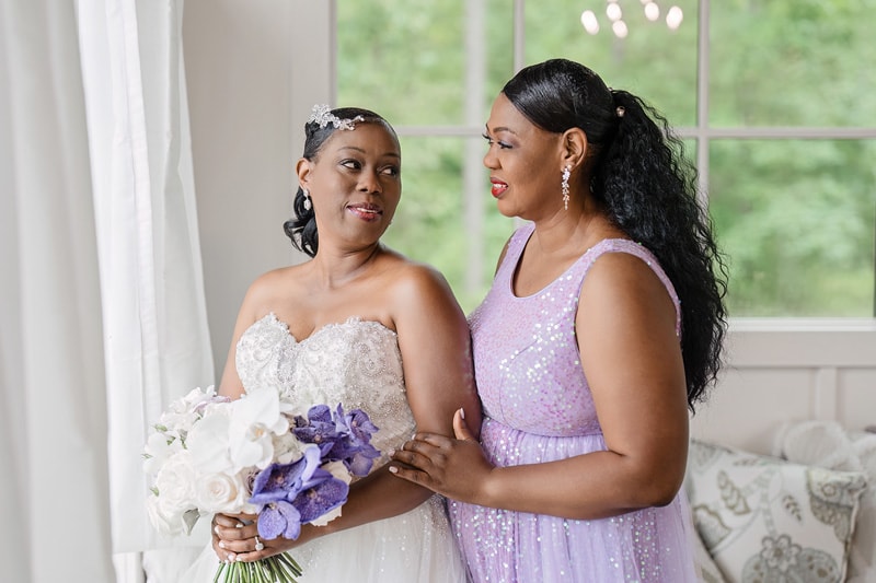 The bride and maid of honor standing next to each other in the Pinehill Pavilion Wedding room.