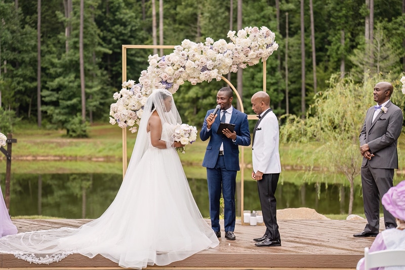 At the enchanting Pinehill Pavilion, a bride and groom exchange heartfelt vows in front of a picturesque pond.