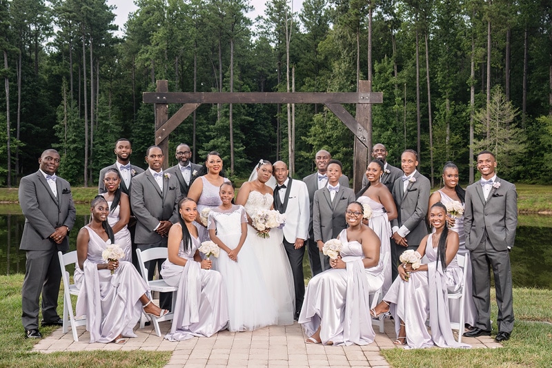 A group of bridesmaids and groomsmen posing for a photo at the Pinehill Pavilion Wedding.