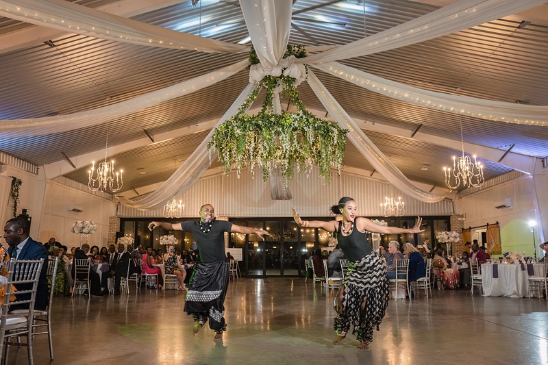 An African dance performance in the elegant Pinehill Pavilion, surrounded by a beautiful chandelier and the joyful presence of their wedding guests.