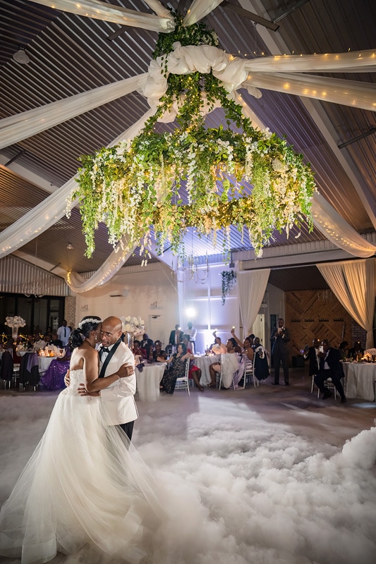A Pinehill Pavilion wedding, with a bride and groom gracefully dancing under a chandelier.