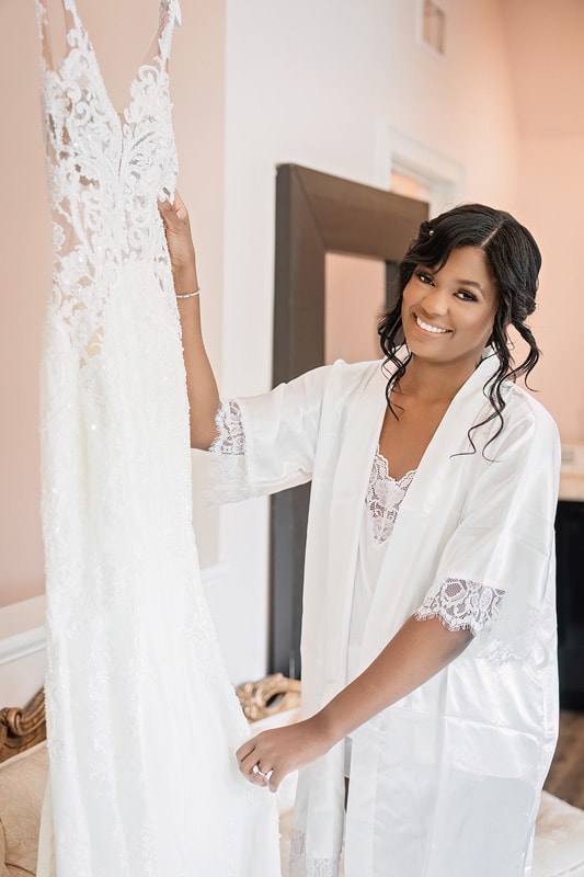 A bride in a robe holding her wedding dress at The Bradford wedding venue.
