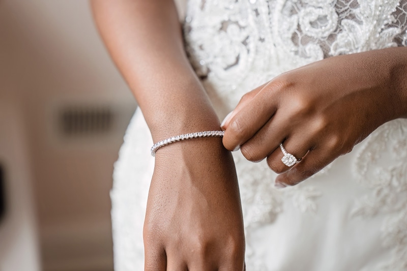 A bride is holding her wedding ring and bracelet at The Bradford wedding venue.
