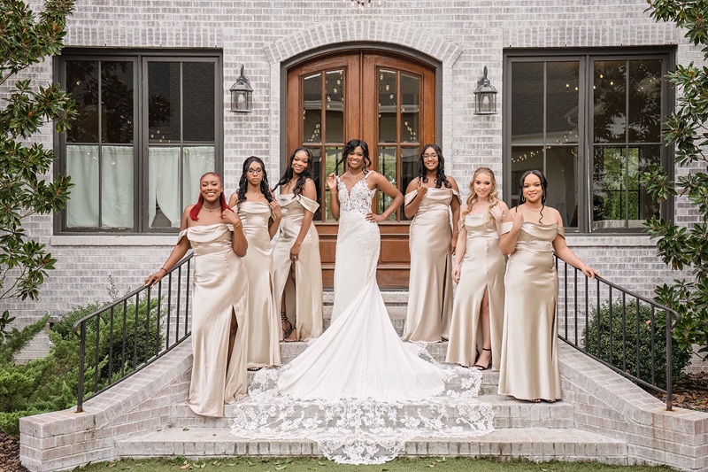 A bride and her bridesmaids pose in front of The Bradford wedding venue.