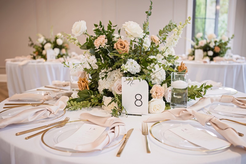A white table setting with flowers and place settings at The Bradford wedding venue.