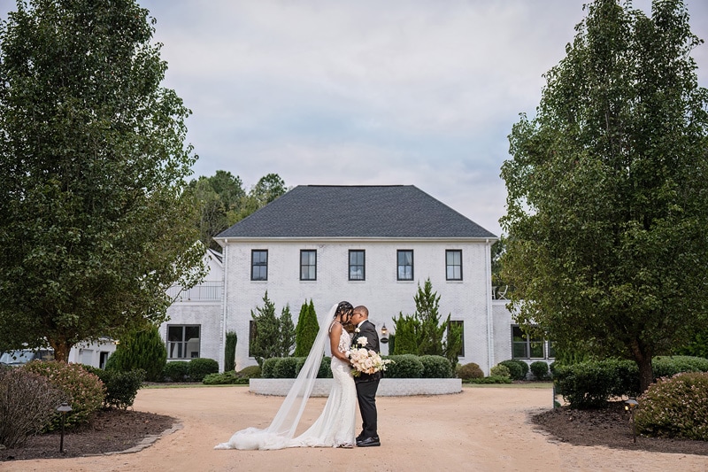 A man and woman kissing in front of The Bradford wedding venue.