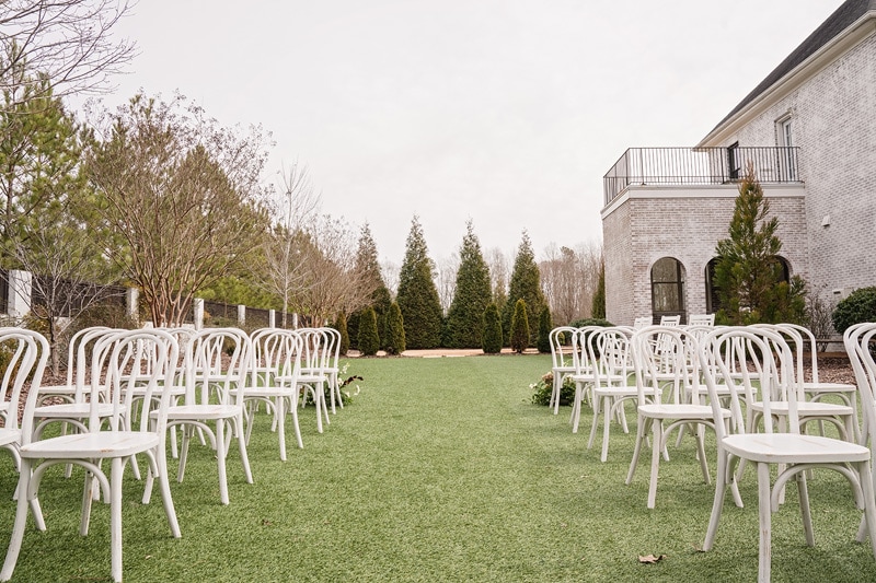 White chairs are arranged on the lawn in front of The Bradford Wedding Venue.