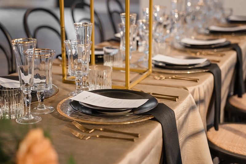 A table setting at The Bradford wedding venue with gold and black plates and silverware.