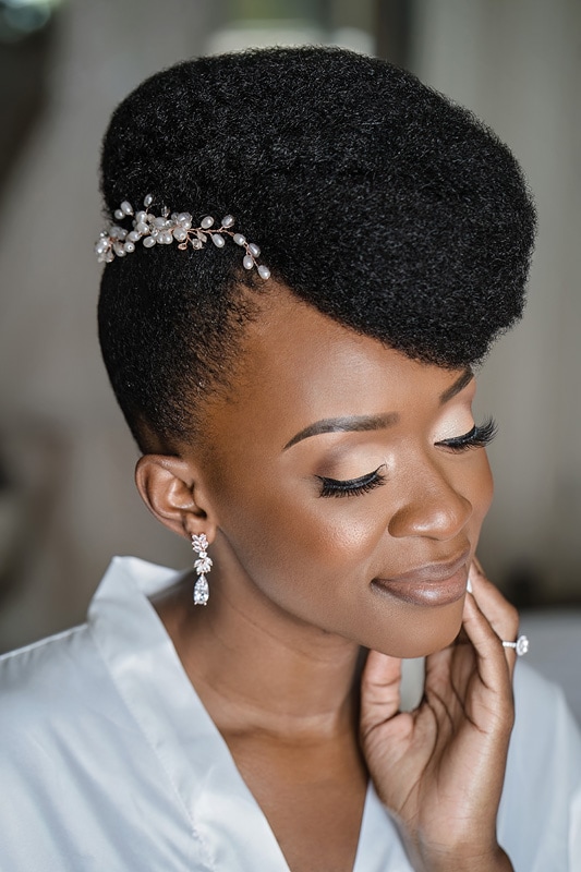 A stunning bride with afro hair and diamond earring celebrating her special day at the distillery wedding.