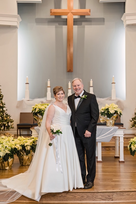 Brad and Shana, a bride and groom, sharing their vows at the Westminster Presbyterian Church Wedding in front of a cross.
