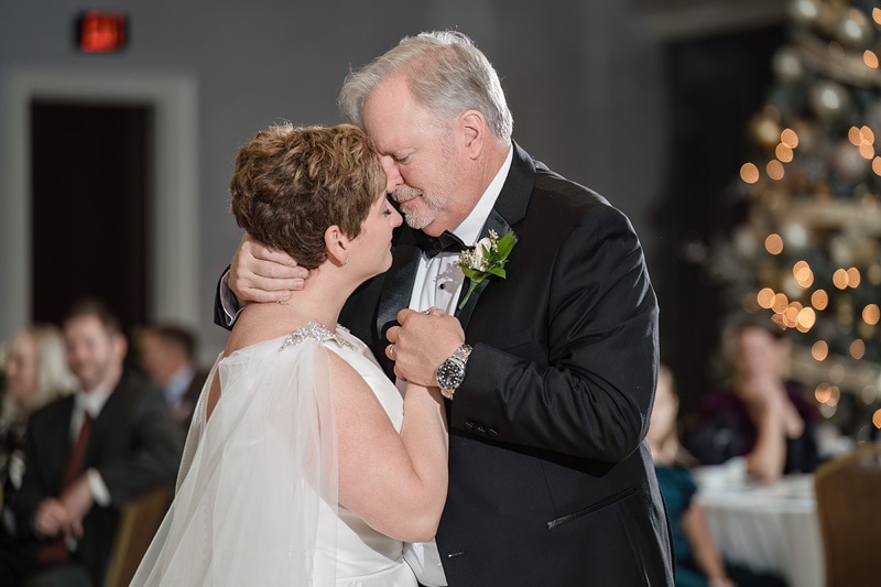 Brad and Shana, a bride and groom, hugging during their first dance at their Grandover Resort & Spa wedding reception.