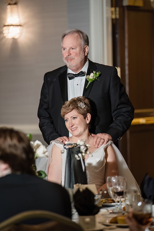 Brad and Shana, a bride and groom, hugging each other joyfully at their wedding reception held at Grandover Resort & Spa.