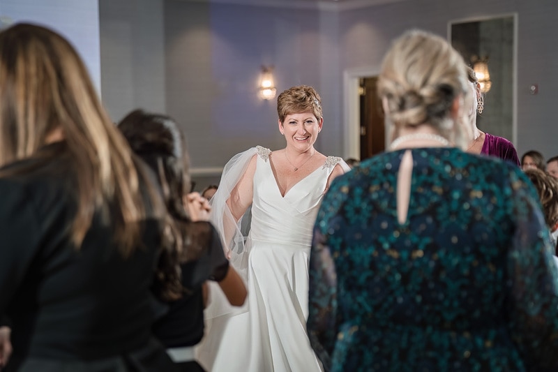 Shana, wearing a white dress, dancing with friends and families during their Grandover Resort & Spa wedding reception.