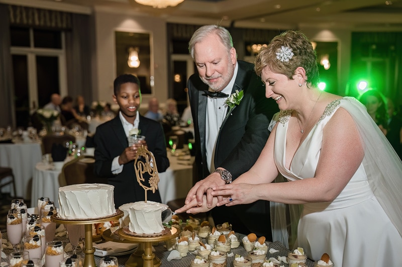 A man and woman cutting a cake at their Grandover Resort & Spa wedding reception.