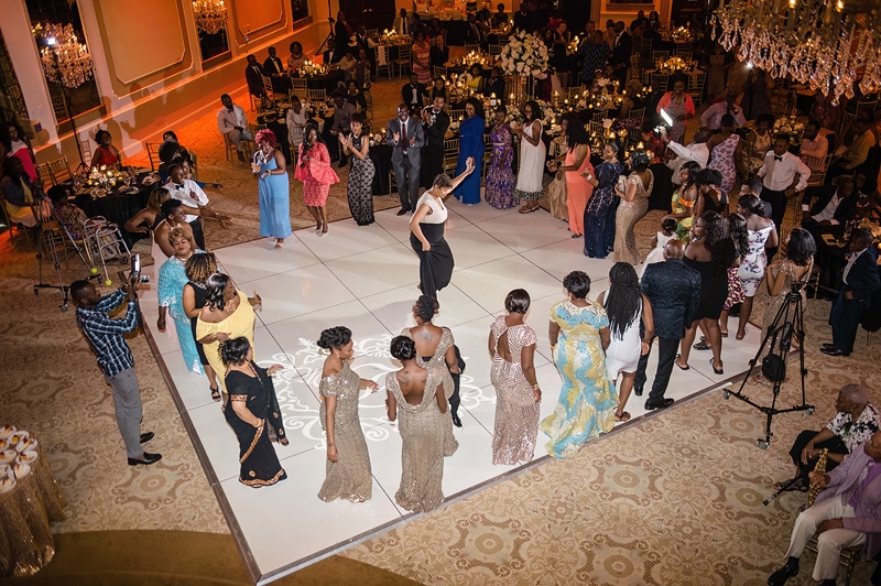 Elegant event in the Grand Marquise Ballroom with guests surrounding a dance floor while a woman stands at the center.